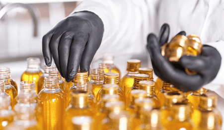 factory worker white gown rubber gloves screwing bottle caps